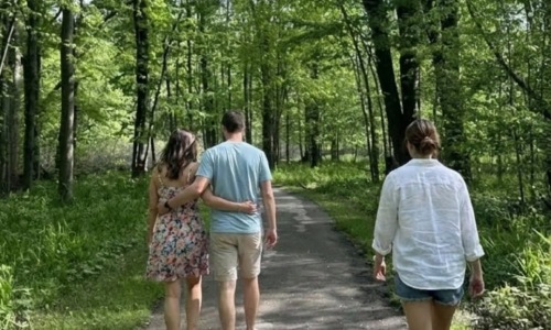 three people walking in a park